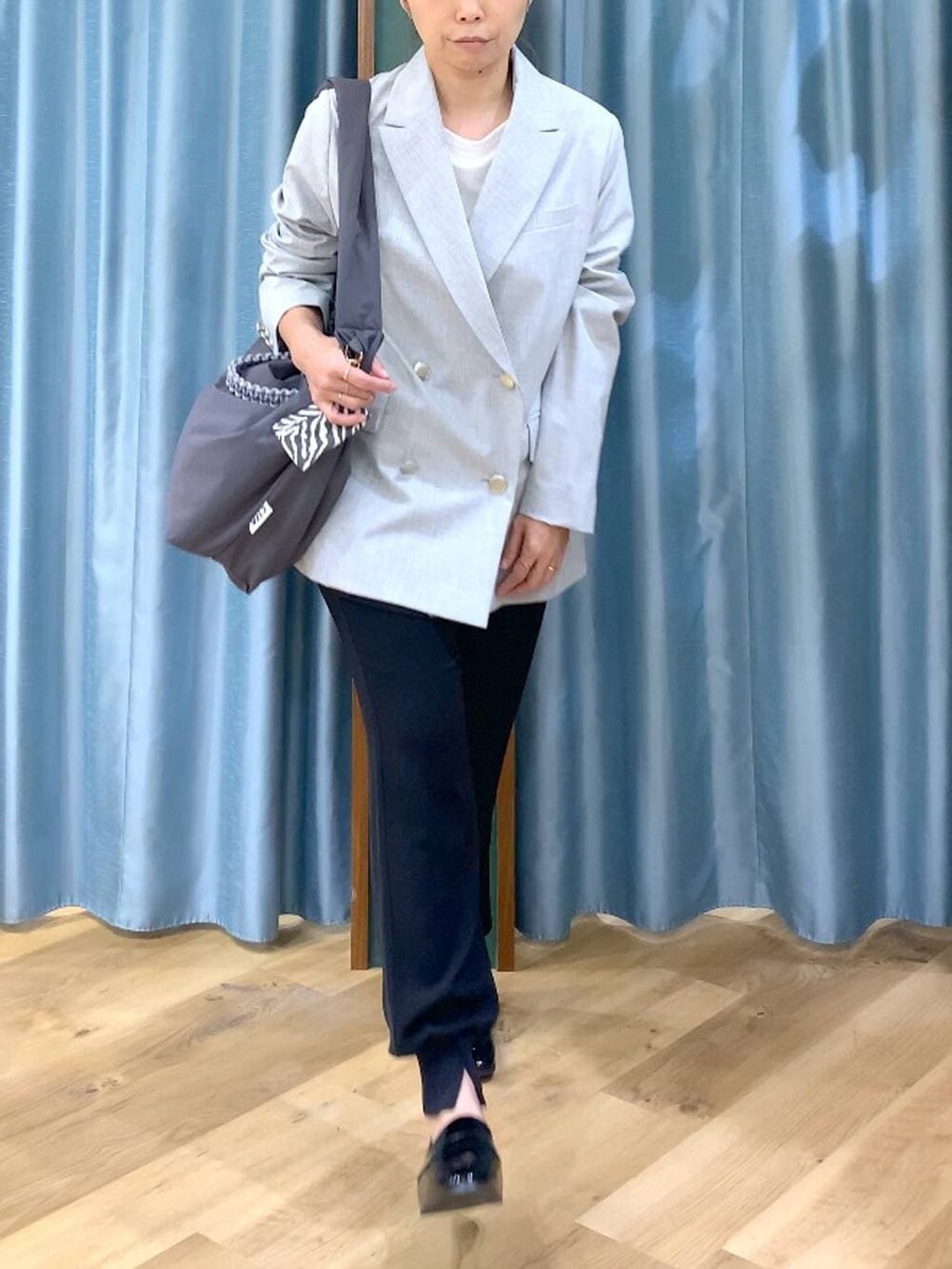 グレー系のショルダーバッグ、ホワイト系のTシャツ/カットソー、グレー系のテーラードジャケットを着用したレディースの冬コーディネートの6枚目の写真