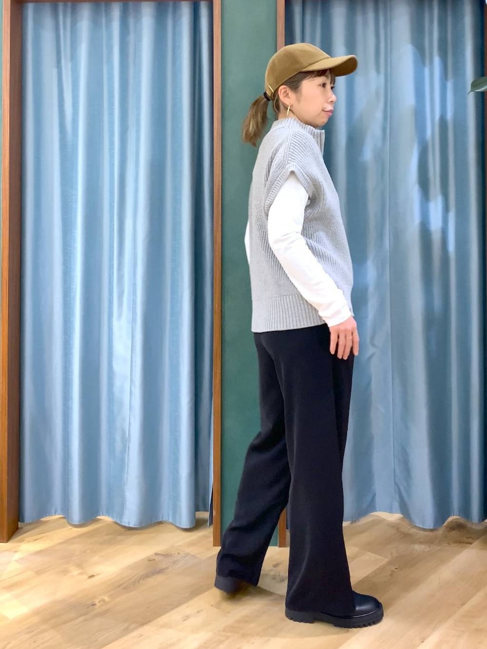 ブラック系のブーツ、ブラック系のスラックス、ホワイト系のTシャツ/カットソーを着用したレディースの冬コーディネートの3枚目の写真