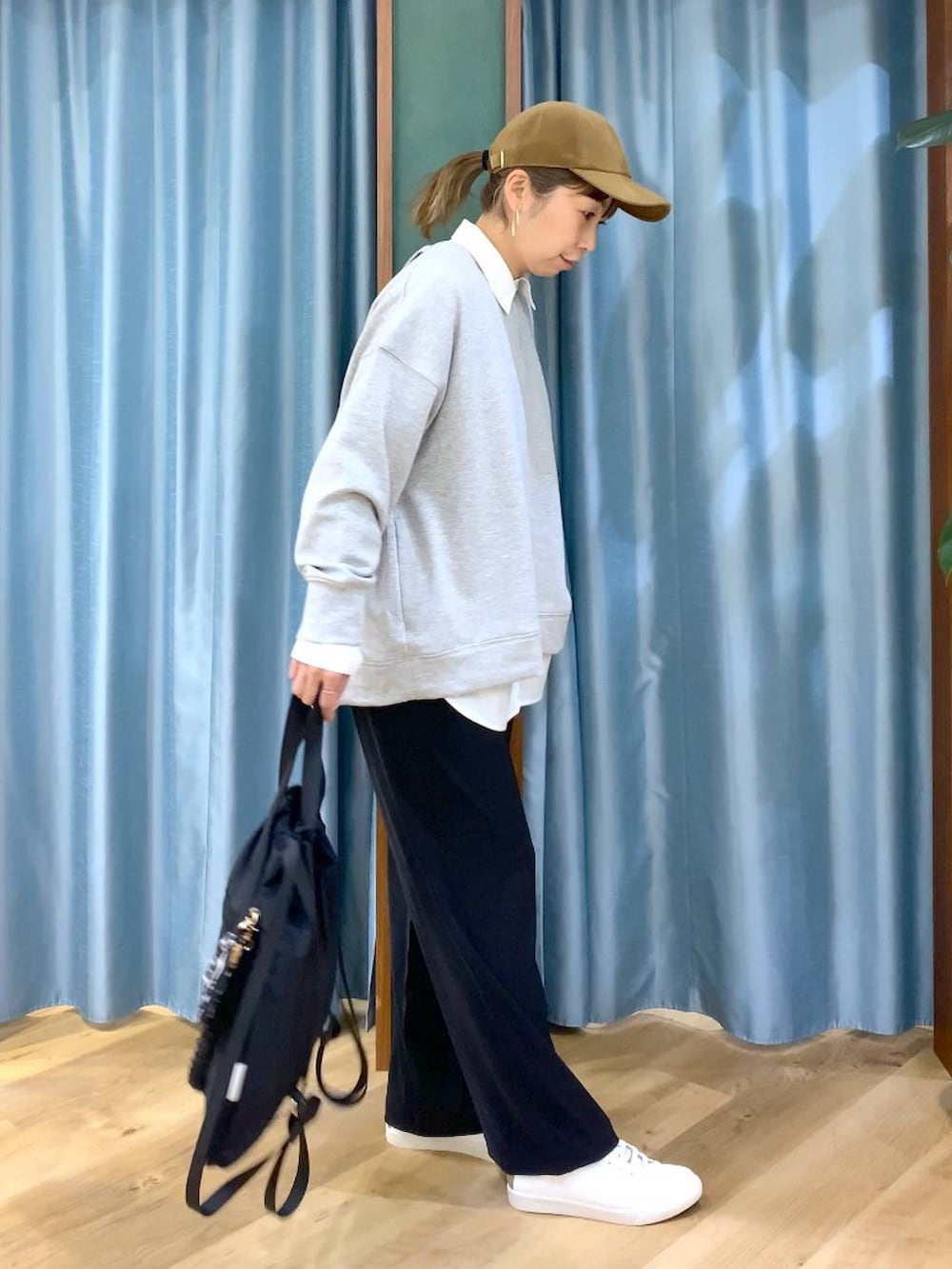 ブラック系のスラックス、グレー系のスウェット、ブラック系のバックパック/リュックを着用したレディースの冬コーディネートの4枚目の写真