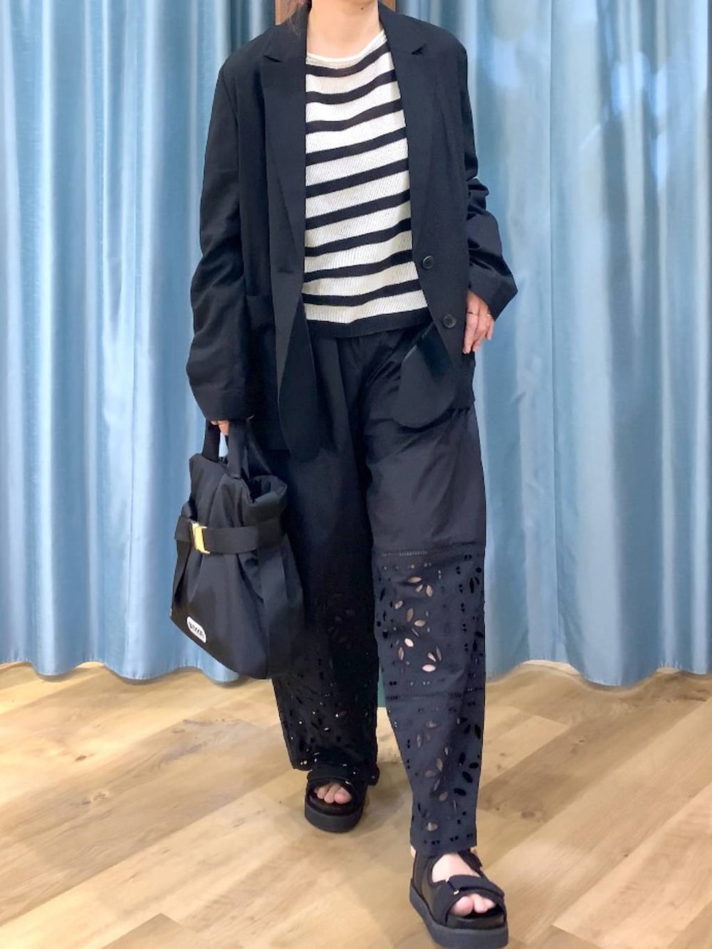 ベージュ系のニット/セーター、ブラック系のテーラードジャケット、ブラック系のその他パンツを着用したレディースの春コーディネートの6枚目の写真