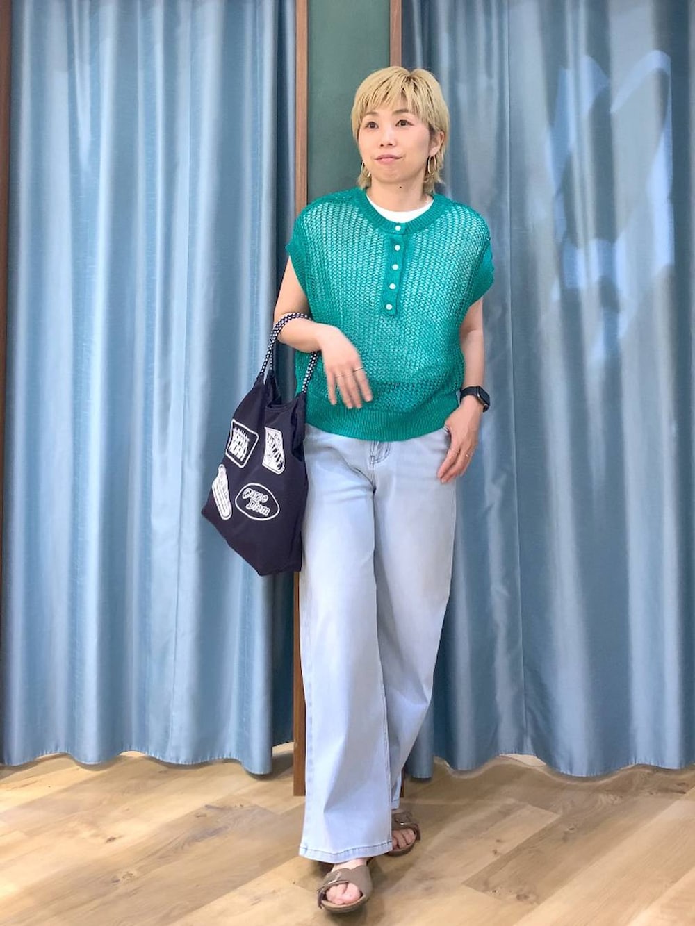ホワイト系のTシャツ/カットソー、ブルー系のデニムパンツ、グリーン系のニット/セーターを着用したレディースの春コーディネートの2枚目の写真