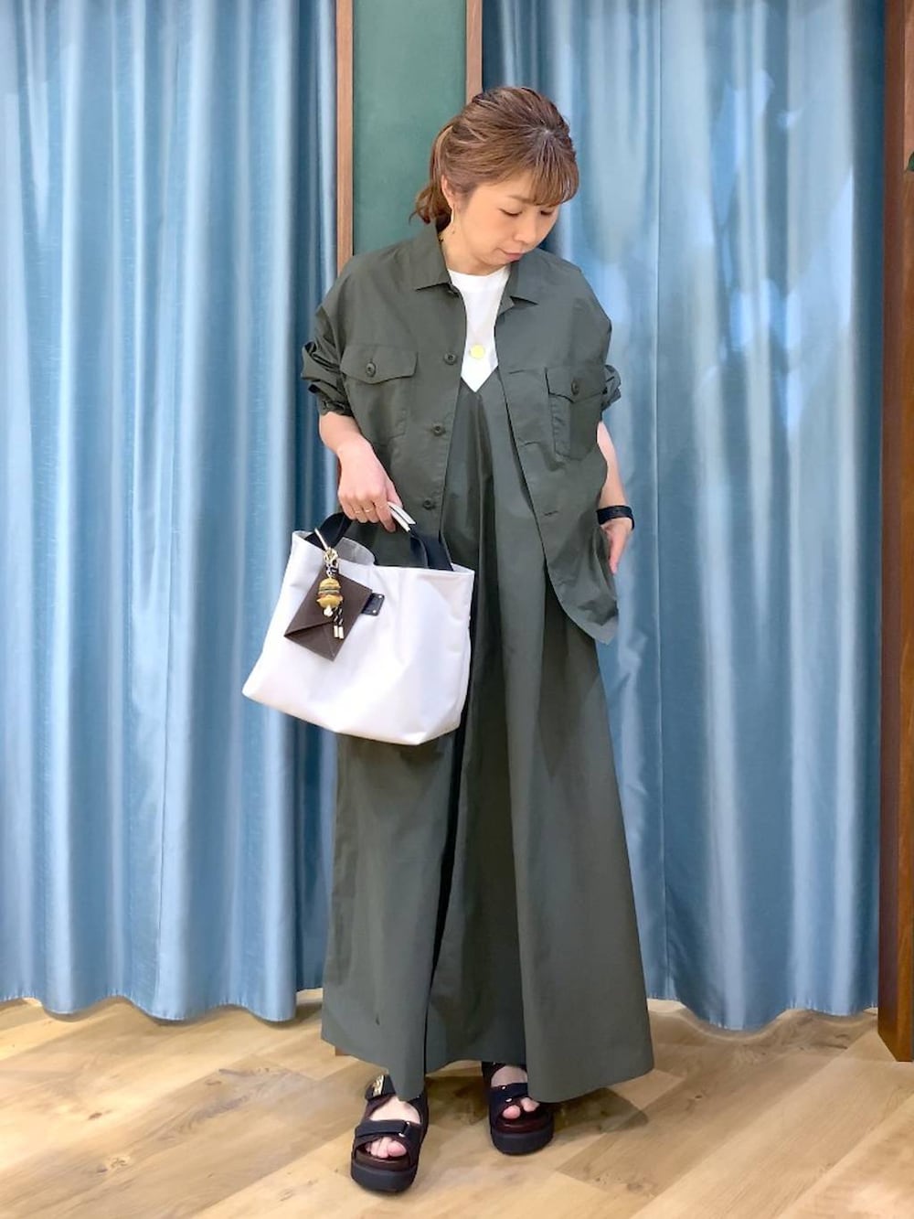 ホワイト系のトートバッグ、グリーン系のシャツ/ブラウス、ホワイト系のTシャツ/カットソーを着用したレディースの春コーディネートの3枚目の写真