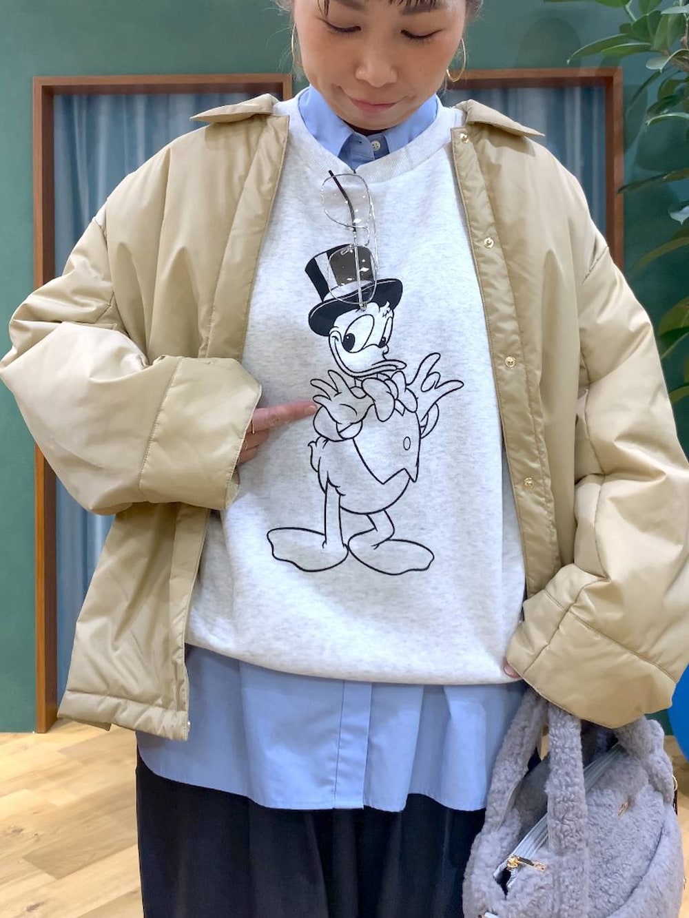 ベージュ系のブルゾン、ブルー系のシャツ/ブラウス、グレー系のスラックスを着用したレディースの秋コーディネートの6枚目の写真