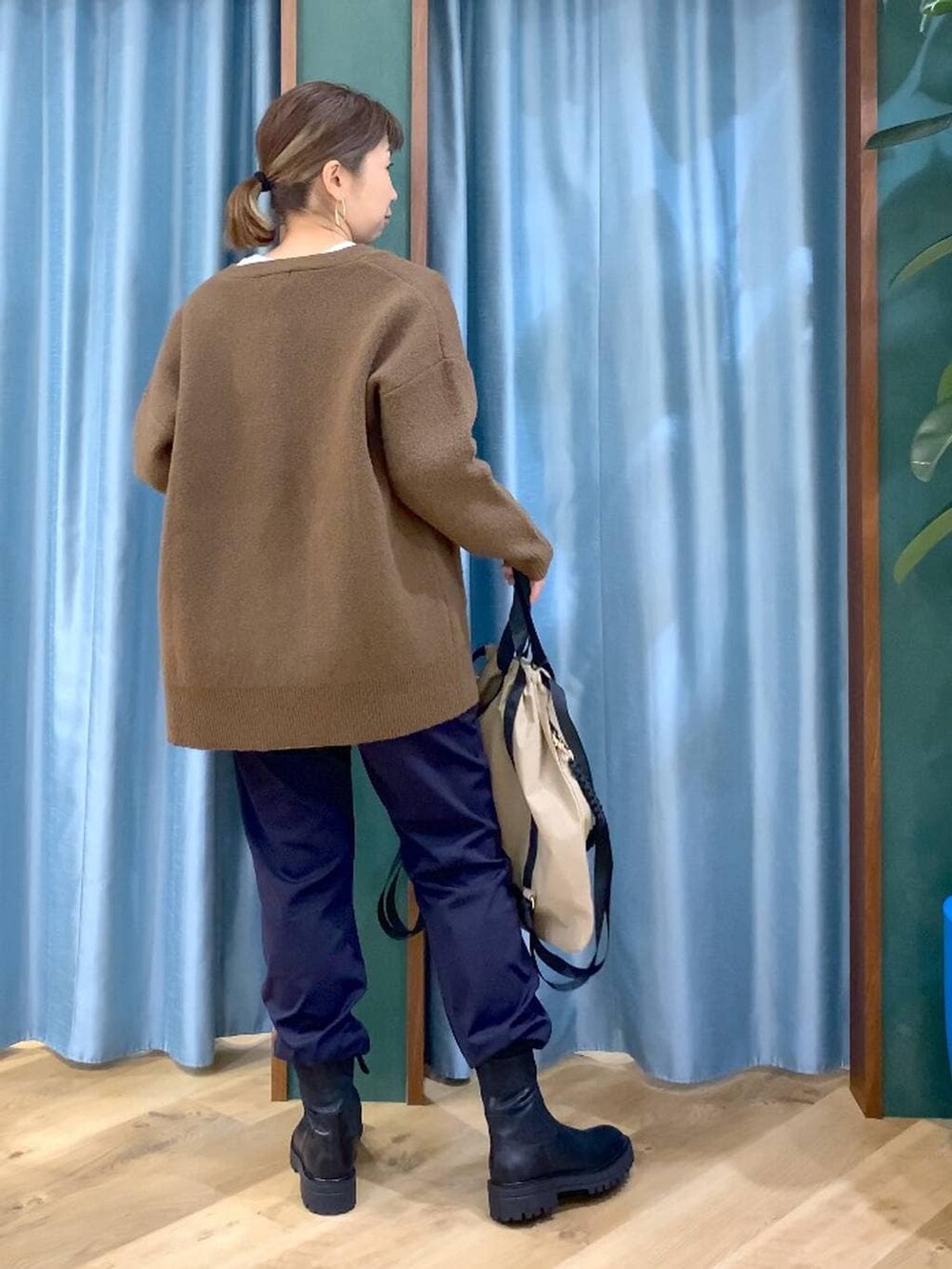 ブラック系のブーツ、ブルー系のその他パンツ、ブラウン系のバックパック/リュックを着用したレディースの冬コーディネートの5枚目の写真