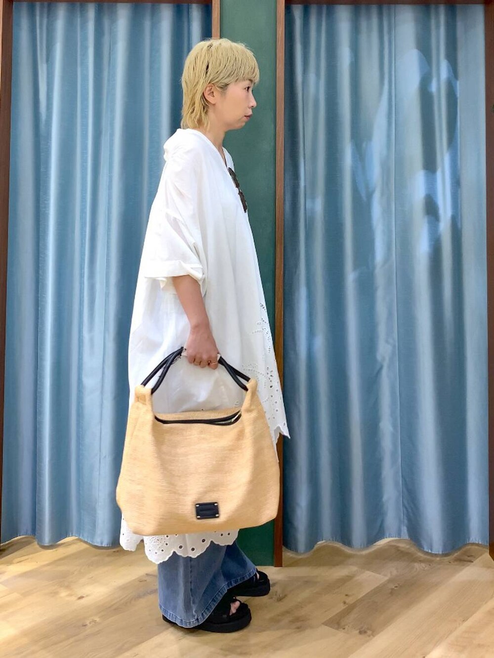 ブルー系のデニムパンツ、ブラック系のサンダル、ベージュ系のトートバッグを着用したレディースの夏コーディネートの4枚目の写真