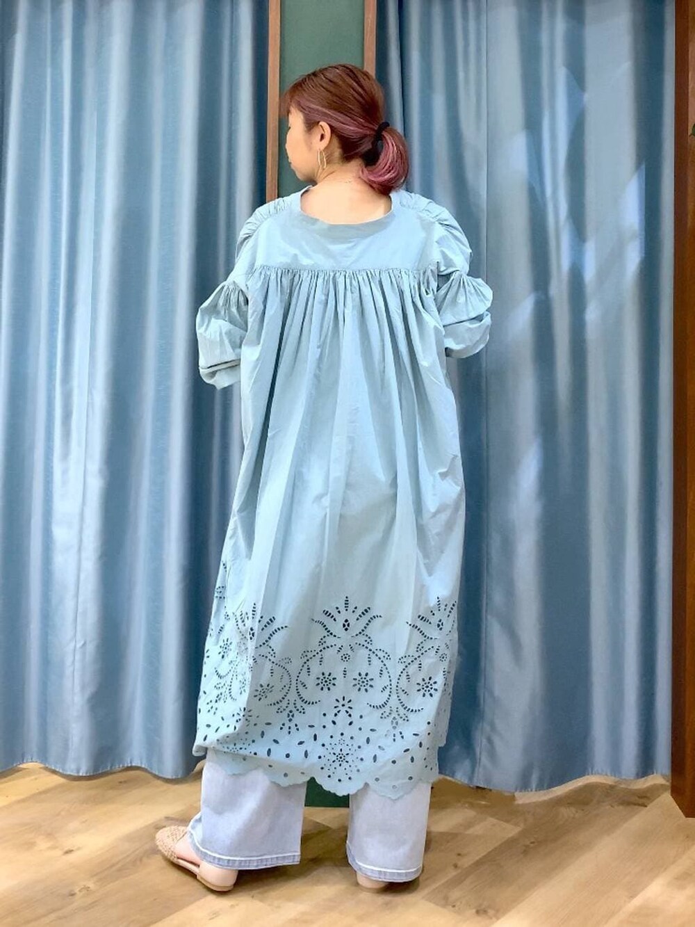 ブルー系のデニムパンツ、ベージュ系のスリッポン、グリーン系のワンピースを着用したレディースの春コーディネートの7枚目の写真