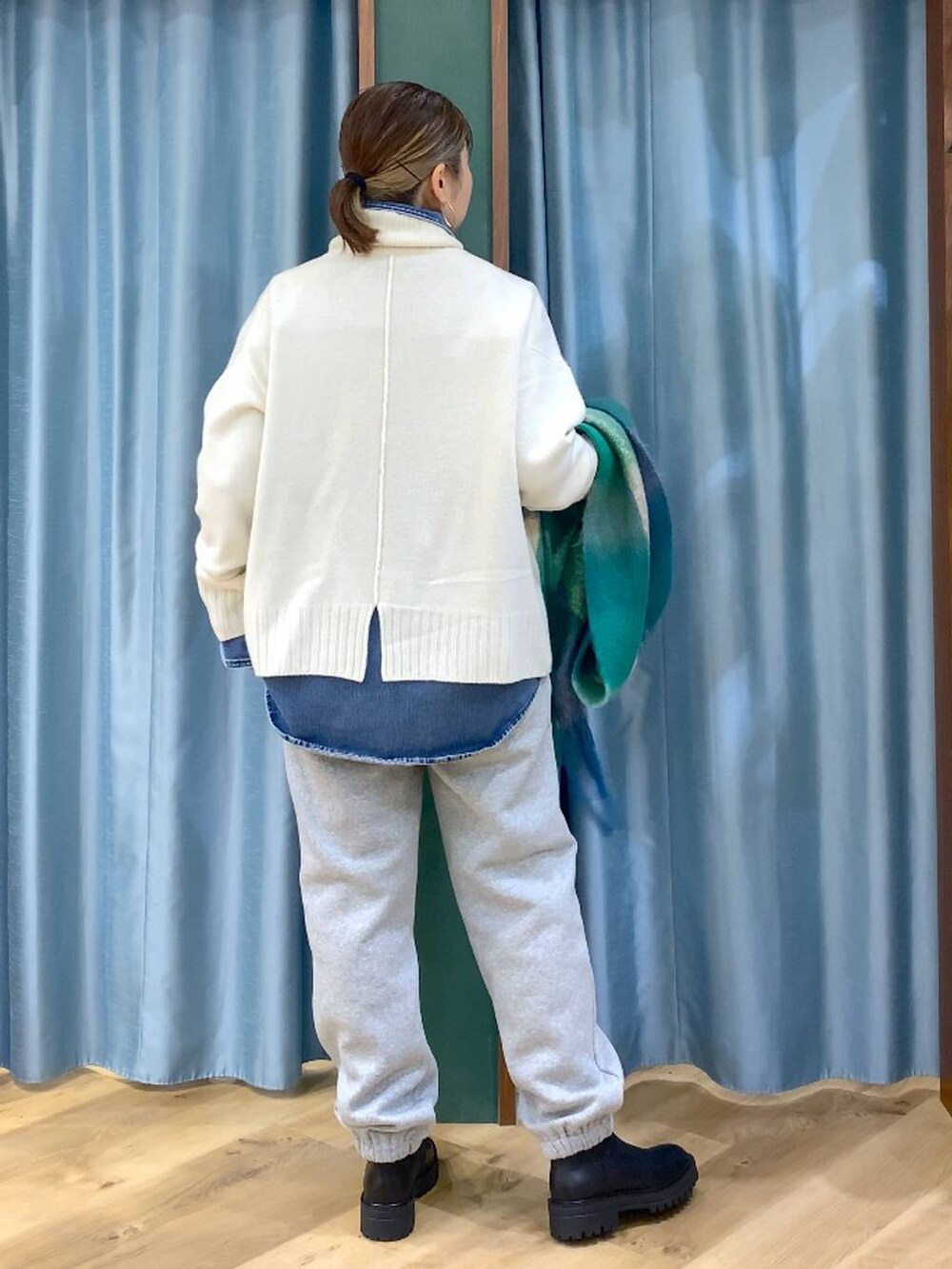 ブラック系のブーツ、ブルー系のシャツ/ブラウス、ホワイト系のニット/セーターを着用したレディースの秋コーディネートの4枚目の写真