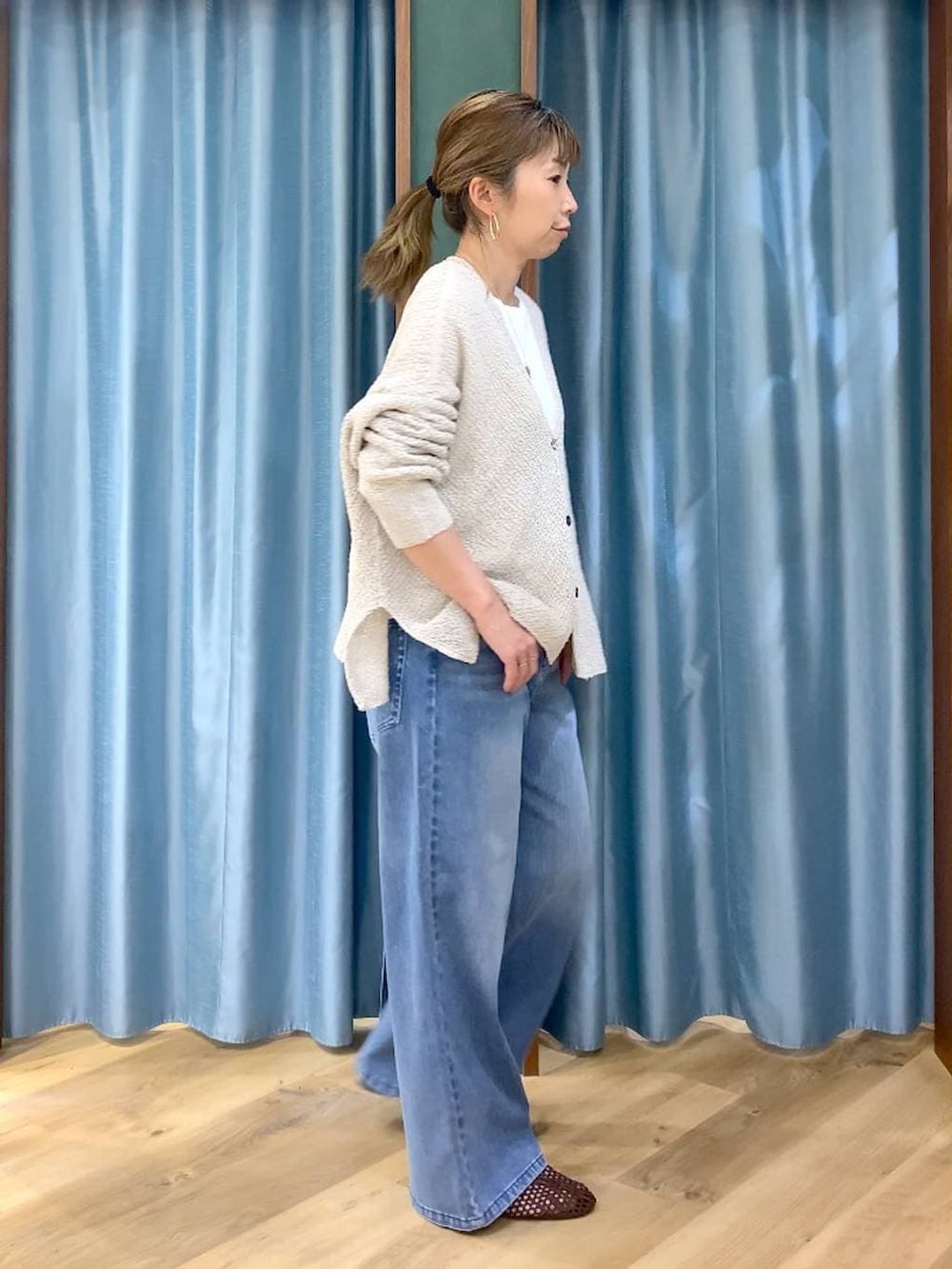 ブルー系のデニムパンツ、ホワイト系のTシャツ/カットソー、ベージュ系のカーディガン/ボレロを着用したレディースの春コーディネートの4枚目の写真