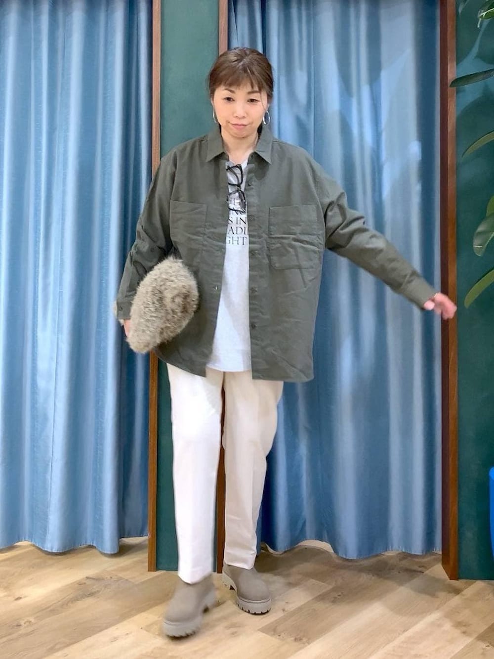 ベージュ系のハンドバッグ、ベージュ系のブーツ、ホワイト系のTシャツ/カットソーを着用したレディースの冬コーディネートの2枚目の写真