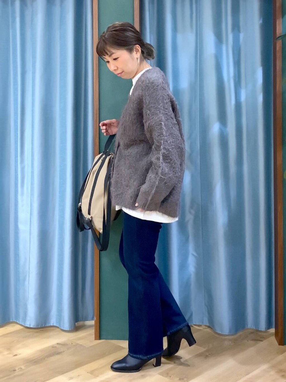 ブルー系のデニムパンツ、ブラック系のブーツ、ホワイト系のTシャツ/カットソーを着用したレディースの秋コーディネートの3枚目の写真