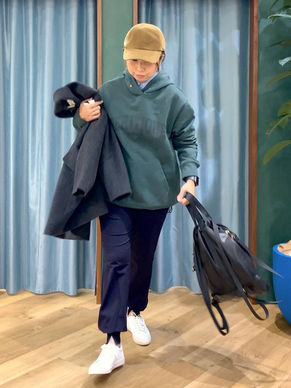 ブラック系のバックパック/リュック、ブルー系のシャツ/ブラウス、グリーン系のパーカーを着用したレディースの秋コーディネートの5枚目の写真