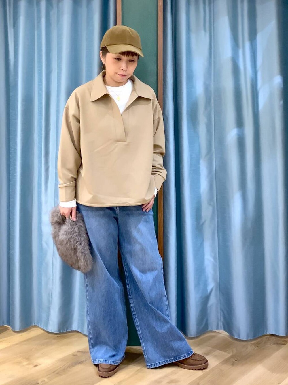 ブルー系のデニムパンツ、ブラウン系のトートバッグ、ブラウン系のローファーを着用したレディースの冬コーディネートの2枚目の写真