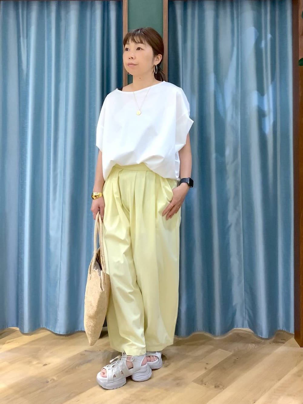 ホワイト系のTシャツ/カットソー、イエロー系のその他パンツ、グレー系のサンダルを着用したレディースの春コーディネートの4枚目の写真