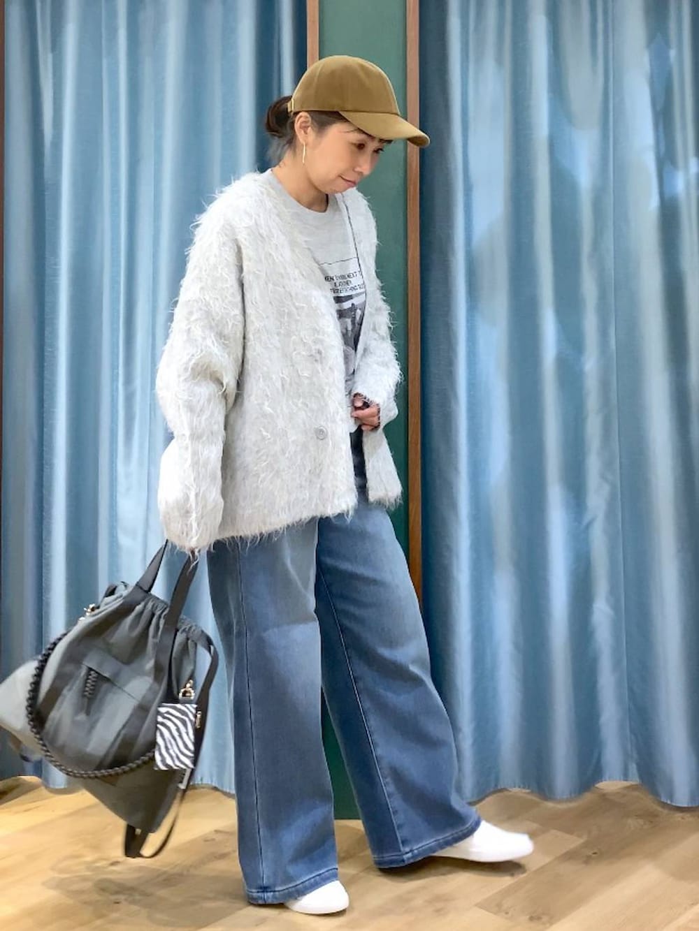 ブルー系のデニムパンツ、グレー系のTシャツ/カットソー、グレー系のバックパック/リュックを着用したレディースの秋コーディネートの4枚目の写真