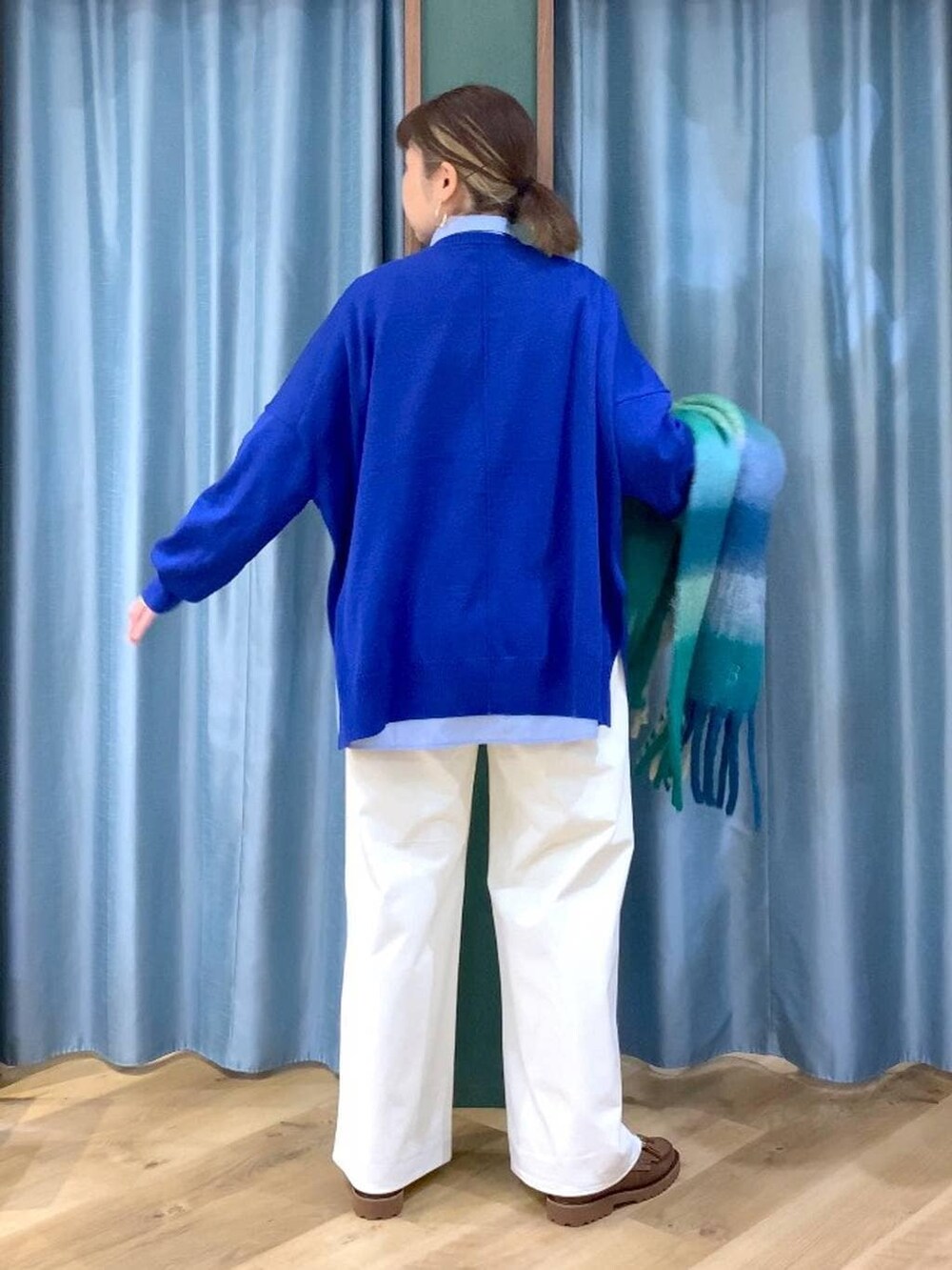 ブルー系のシャツ/ブラウス、ブラウン系のローファー、ブルー系のニット/セーターを着用したレディースの秋コーディネートの4枚目の写真