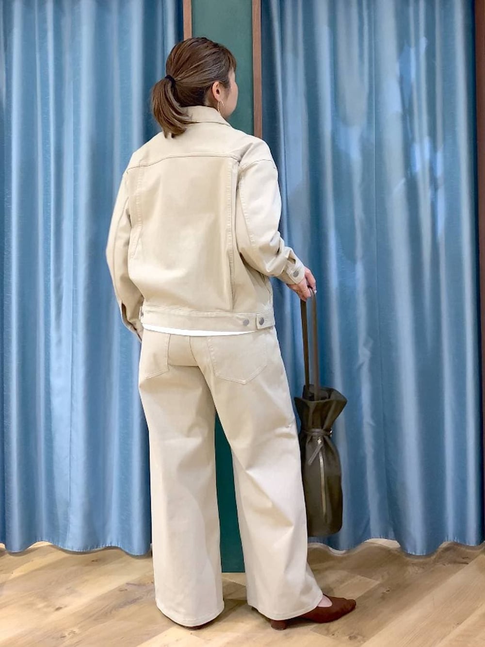 ブラウン系のパンプス、ベージュ系のデニムパンツ、ベージュ系のデニムジャケットを着用したレディースの春コーディネートの5枚目の写真