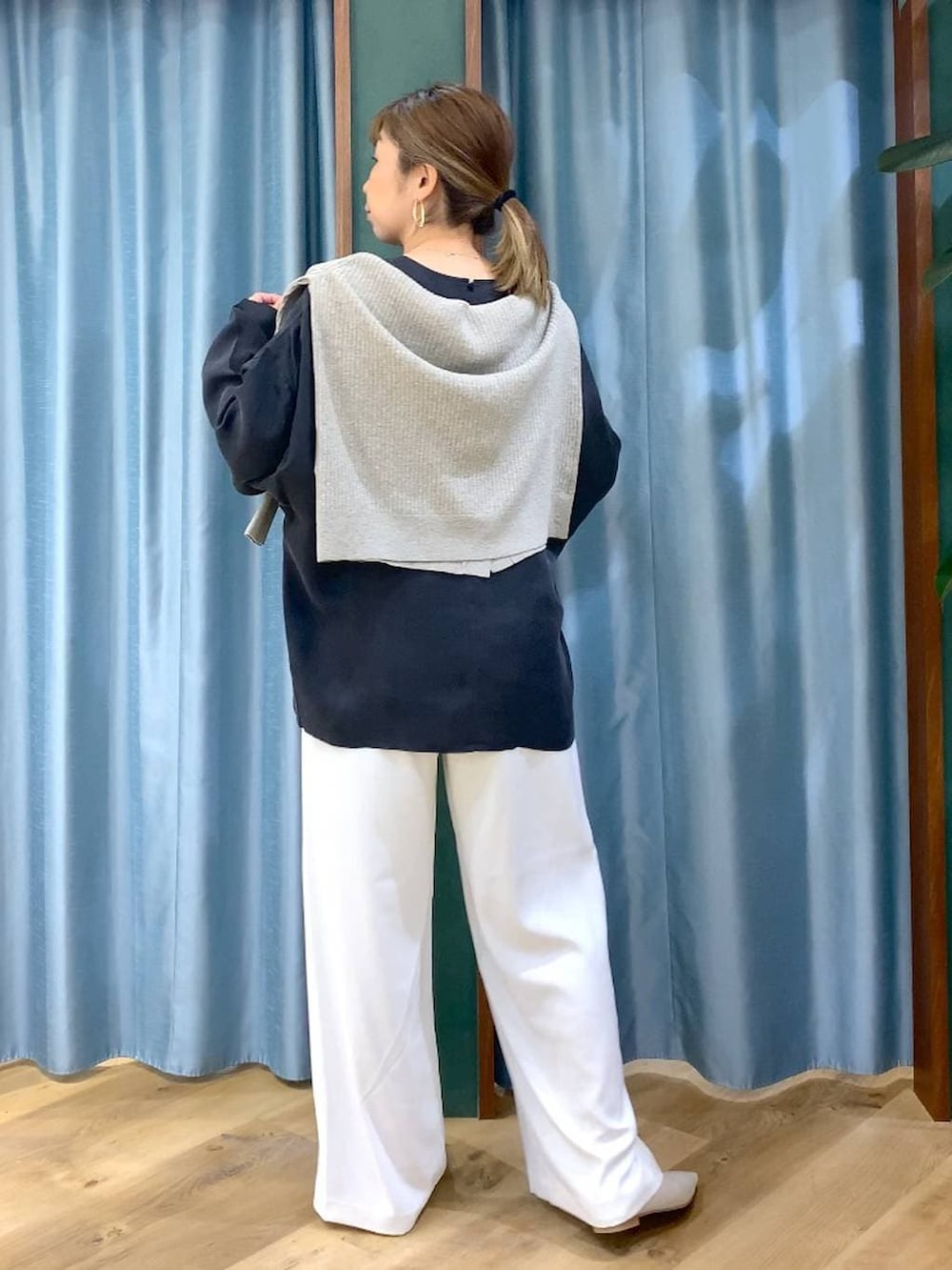 ホワイト系のスラックス、ベージュ系のカーディガン/ボレロ、ホワイト系のパンプスを着用したレディースの冬コーディネートの9枚目の写真