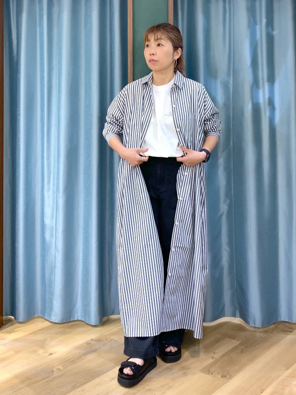 ホワイト系のTシャツ/カットソー、ブルー系のワンピース、グレー系のデニムパンツを着用したレディースの春コーディネートの7枚目の写真