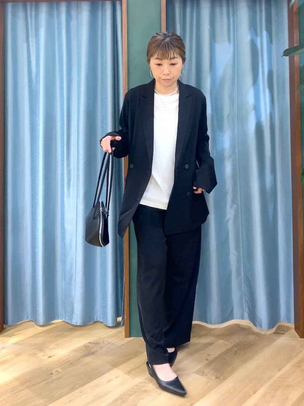 ブラック系のスラックス、ホワイト系のTシャツ/カットソー、ブラック系のテーラードジャケットを着用したレディースの冬コーディネートの4枚目の写真