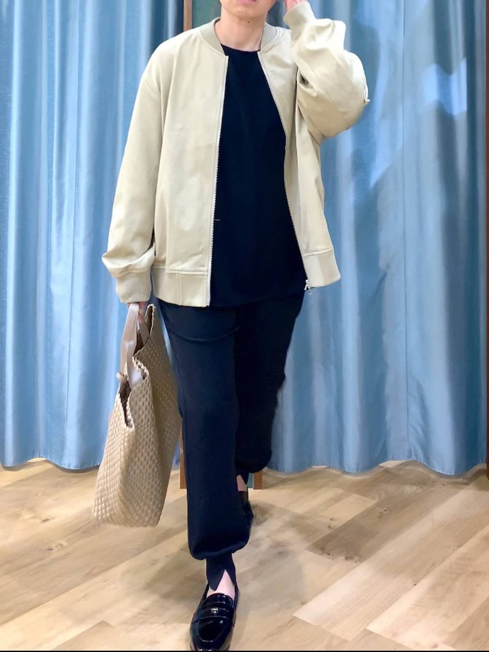 ベージュ系のMA-1、ブラック系のTシャツ/カットソー、ベージュ系のトートバッグを着用したレディースの冬コーディネートの6枚目の写真