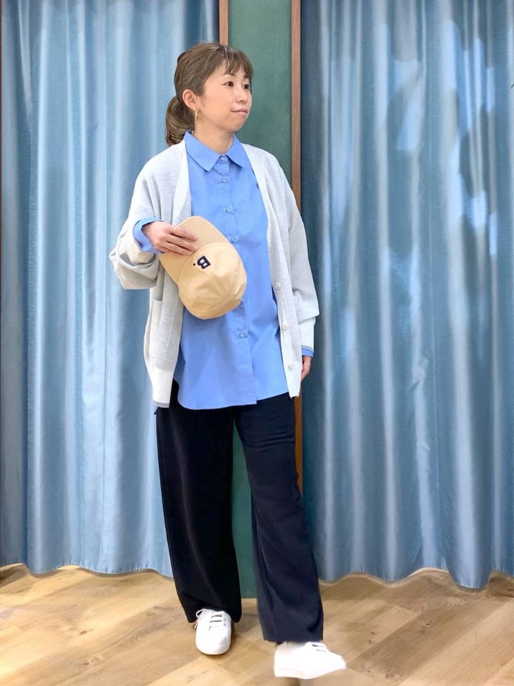 ブラック系のスラックス、ホワイト系のカーディガン/ボレロ、ブルー系のシャツ/ブラウスを着用したレディースの冬コーディネートの2枚目の写真