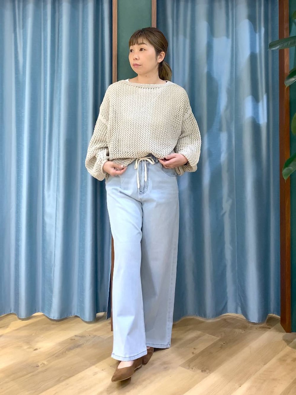 ベージュ系のニット/セーター、ブラウン系のトートバッグ、ホワイト系のTシャツ/カットソーを着用したレディースの冬コーディネートの2枚目の写真