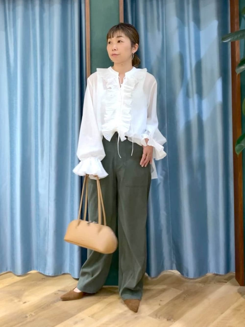 グリーン系のその他パンツ、ホワイト系のシャツ/ブラウス、イエロー系のパンプスを着用したレディースの冬コーディネートの2枚目の写真