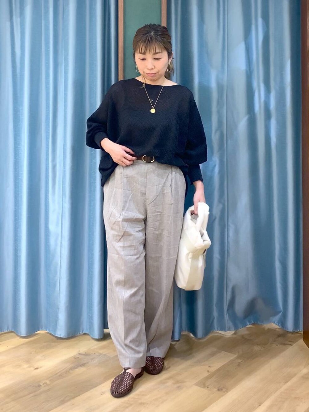 ブラック系のニット/セーター、ベージュ系のその他パンツ、ホワイト系のトートバッグを着用したレディースの春コーディネートの3枚目の写真