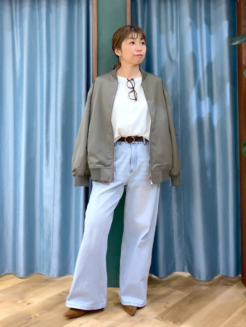 ブルー系のデニムパンツ、ホワイト系のTシャツ/カットソー、グリーン系のMA-1を着用したレディースの冬コーディネートの9枚目の写真