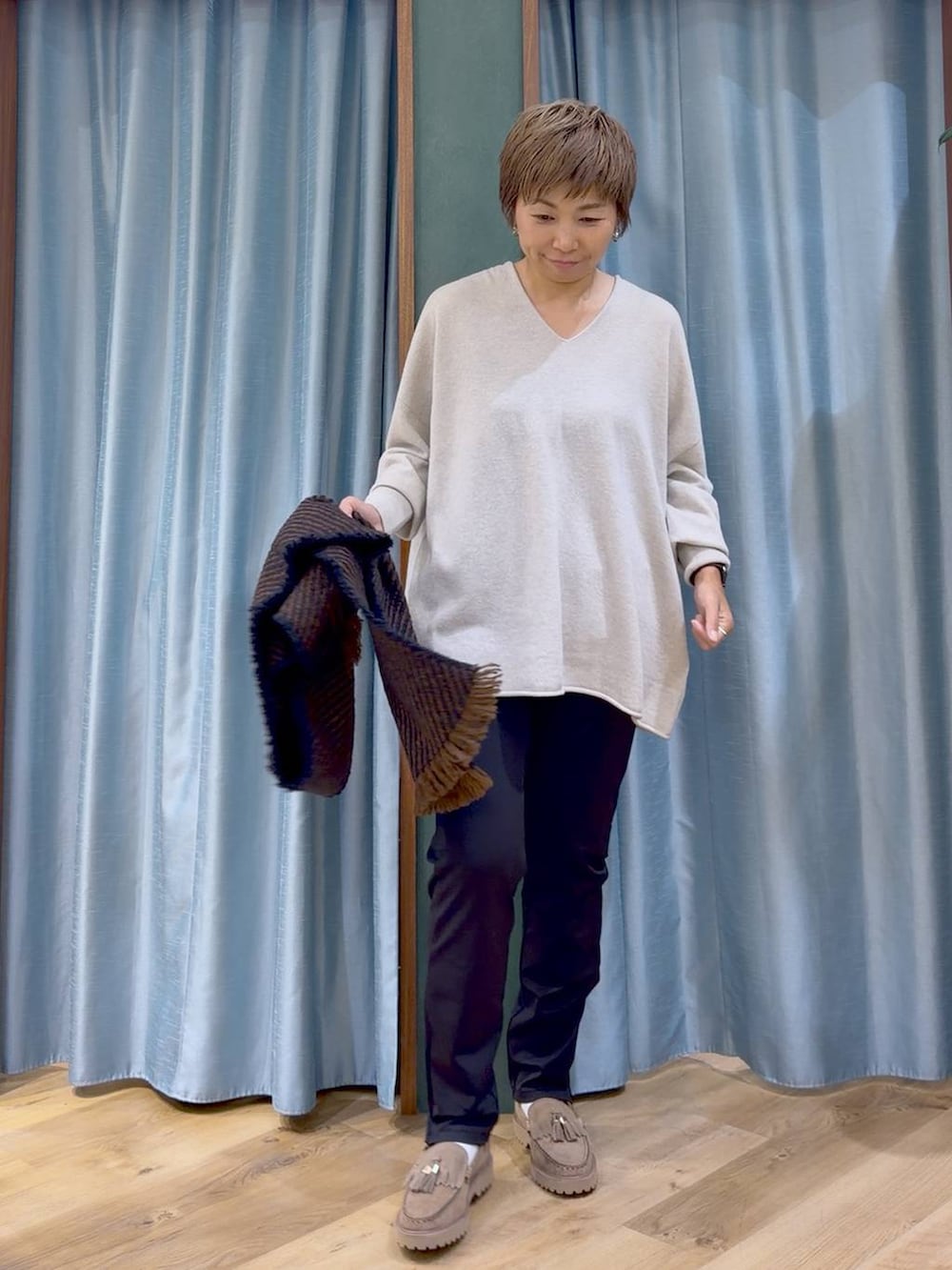 ブラック系のその他パンツ、ベージュ系のローファー、ベージュ系のニット/セーターを着用したレディースの秋コーディネートの2枚目の写真