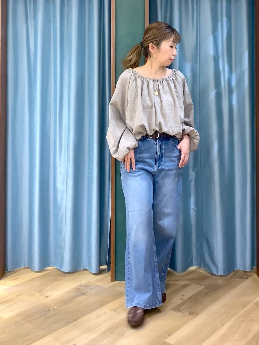 ブルー系のデニムパンツ、ベージュ系のシャツ/ブラウス、ブラウン系のスリッポンを着用したレディースの春コーディネートの4枚目の写真