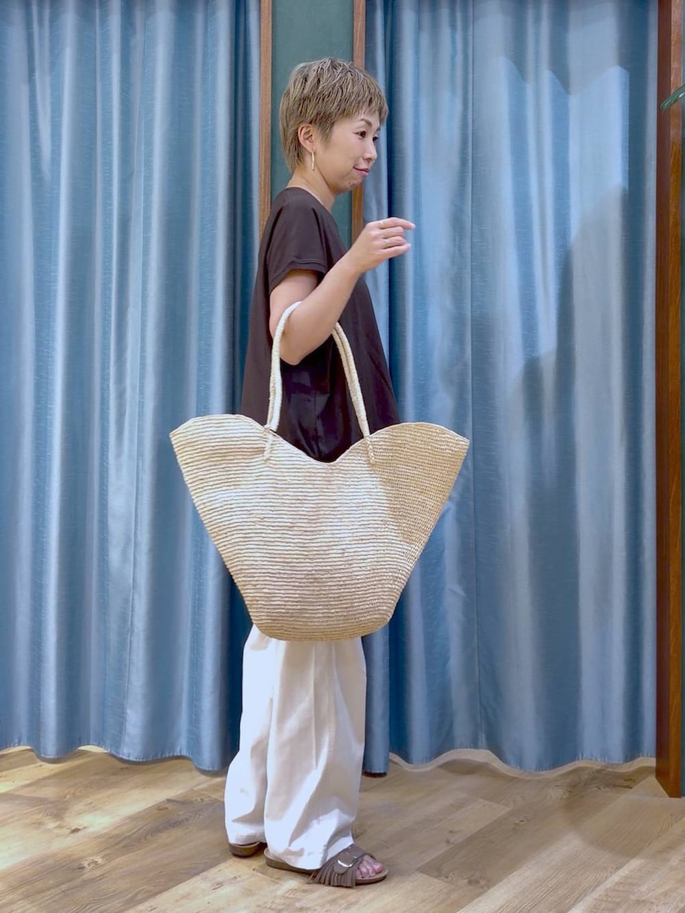 ブラウン系のTシャツ/カットソー、ホワイト系のチノパンツ、ブラウン系のサンダルを着用したレディースの夏コーディネートの3枚目の写真