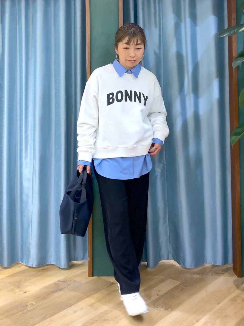 ブラック系のスラックス、ブルー系のトートバッグ、ブルー系のシャツ/ブラウスを着用したレディースの冬コーディネートの7枚目の写真