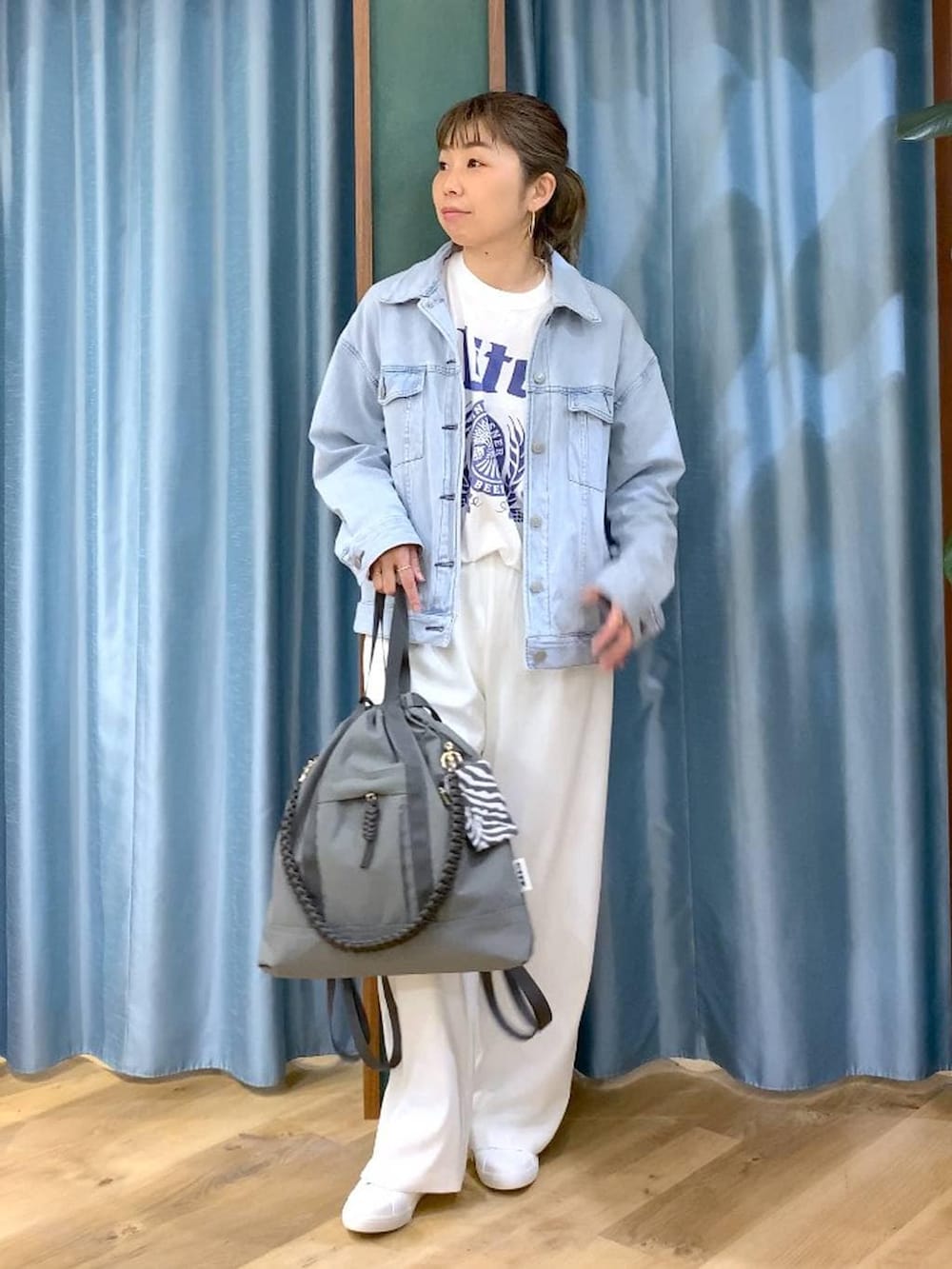 ホワイト系のスラックス、ブルー系のデニムジャケット、ホワイト系のTシャツ/カットソーを着用したレディースの冬コーディネートの2枚目の写真