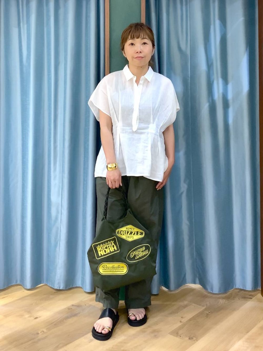 グリーン系のその他パンツ、ホワイト系のシャツ/ブラウス、ブラック系のサンダルを着用したレディースの春コーディネートの2枚目の写真