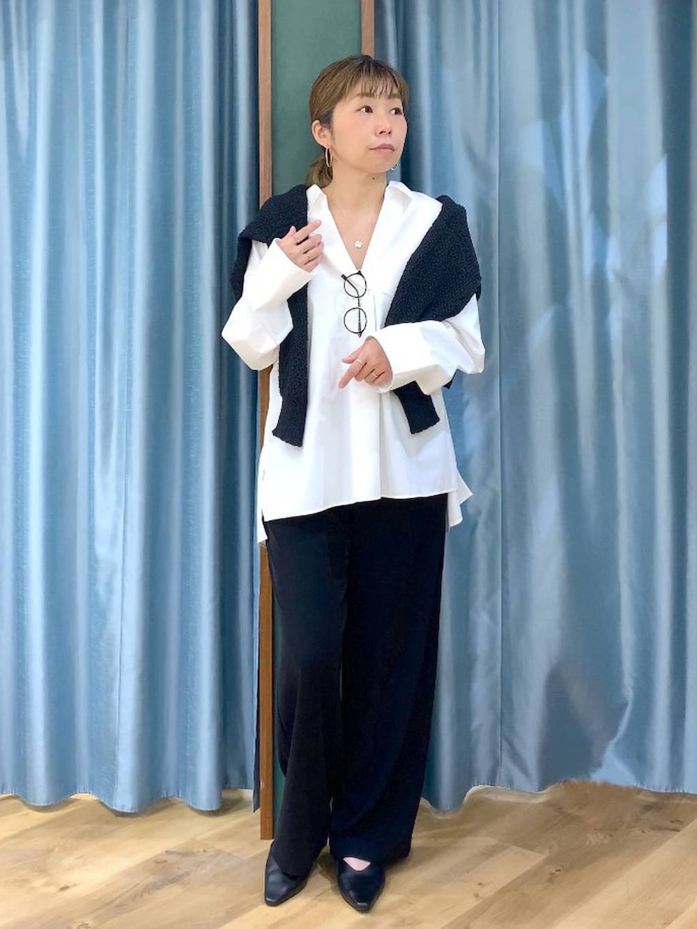 ブラック系のスラックス、ブラック系のカーディガン/ボレロ、ブラック系のパンプスを着用したレディースの春コーディネートの2枚目の写真