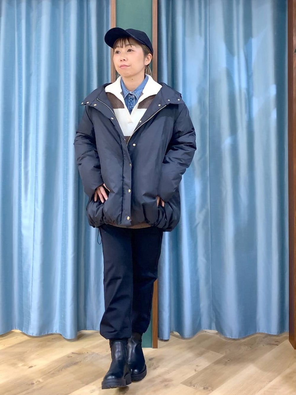 ブラック系のブーツ、ホワイト系のニット/セーター、ブルー系のシャツ/ブラウスを着用したレディースの冬コーディネートの4枚目の写真