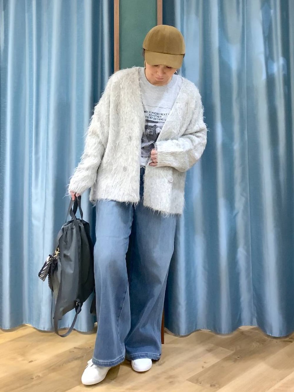 ブルー系のデニムパンツ、グレー系のTシャツ/カットソー、グレー系のバックパック/リュックを着用したレディースの秋コーディネートの2枚目の写真