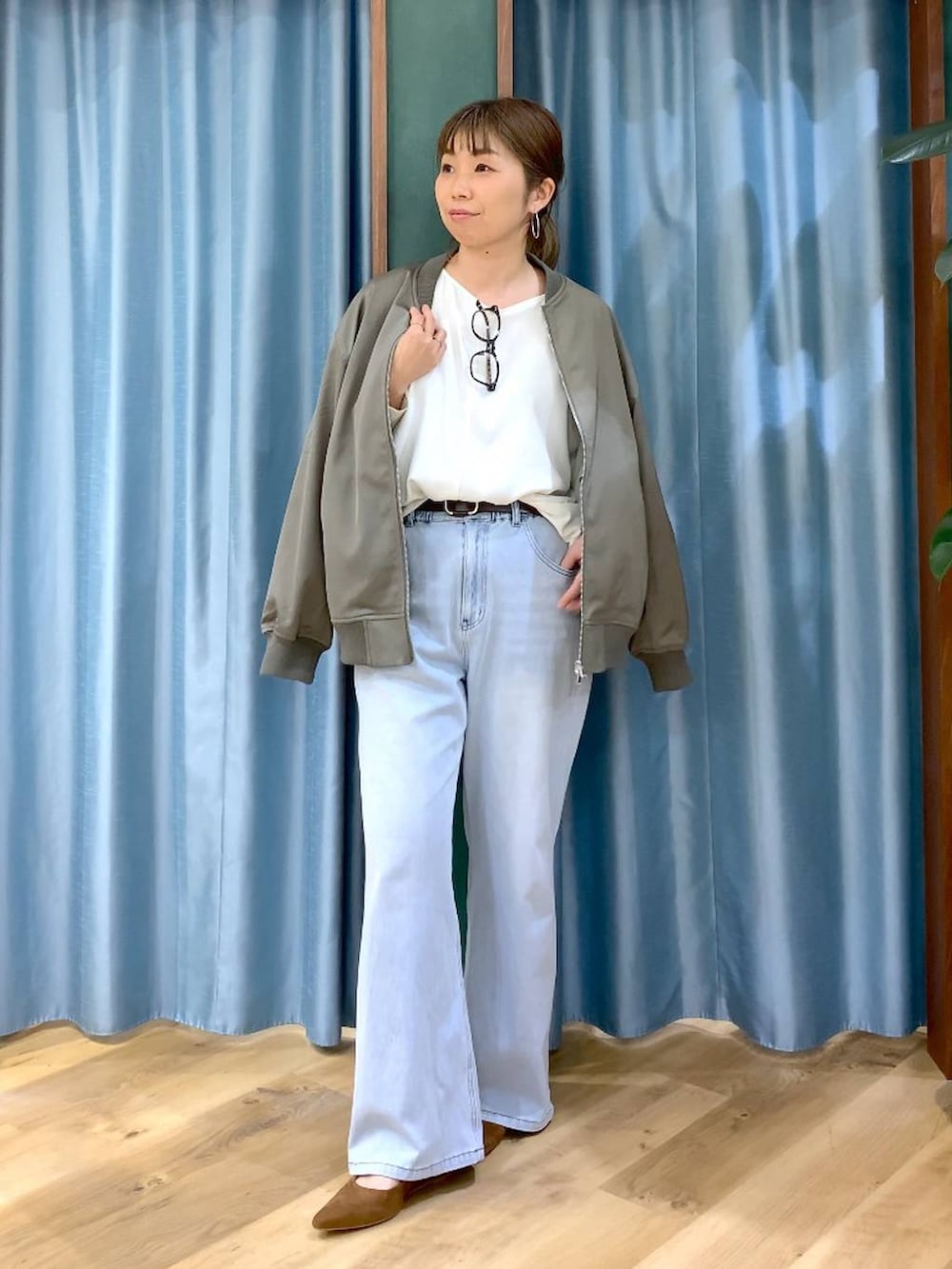 ブルー系のデニムパンツ、ホワイト系のTシャツ/カットソー、グリーン系のMA-1を着用したレディースの冬コーディネートの2枚目の写真