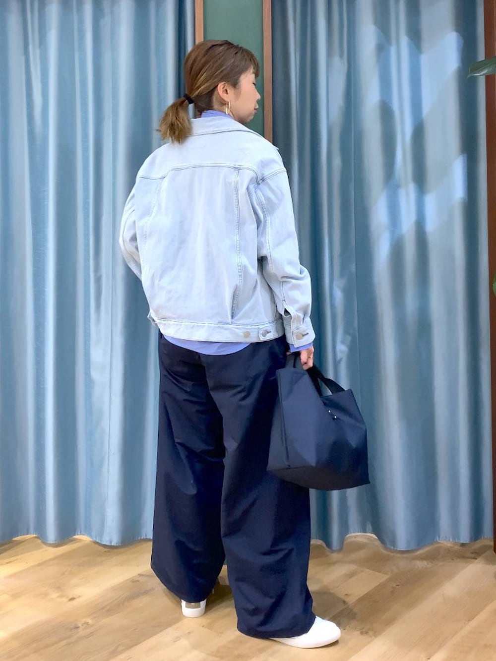 ブルー系のトートバッグ、ブルー系のデニムジャケット、ブルー系のシャツ/ブラウスを着用したレディースの冬コーディネートの4枚目の写真