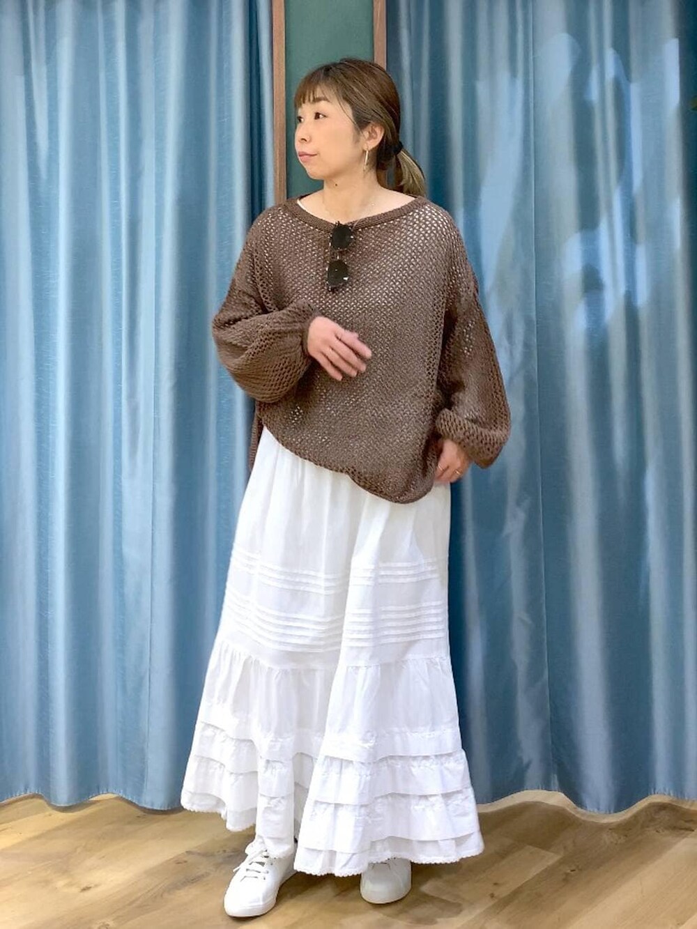 ブラウン系のスニーカー、ブラウン系のニット/セーター、ホワイト系のスカートを着用したレディースの冬コーディネートの5枚目の写真