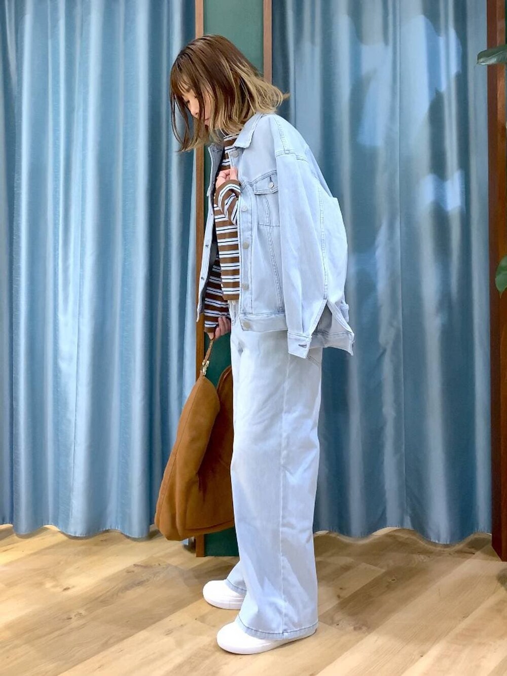 ブラウン系のTシャツ/カットソー、ブルー系のデニムパンツ、ブルー系のデニムジャケットを着用したレディースの冬コーディネートの3枚目の写真