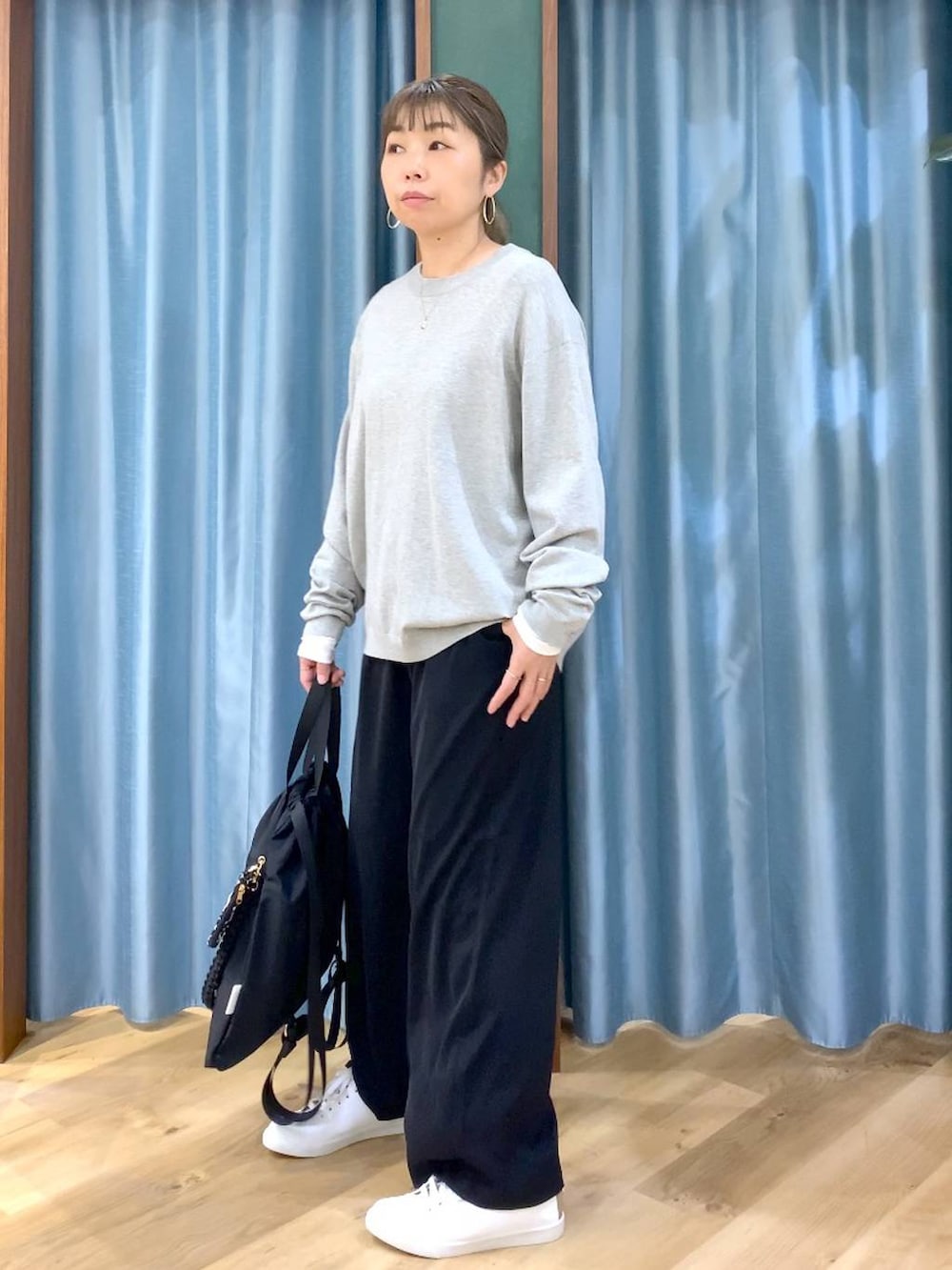 ブラック系のスラックス、ホワイト系のTシャツ/カットソー、グレー系のニット/セーターを着用したレディースの冬コーディネートの4枚目の写真