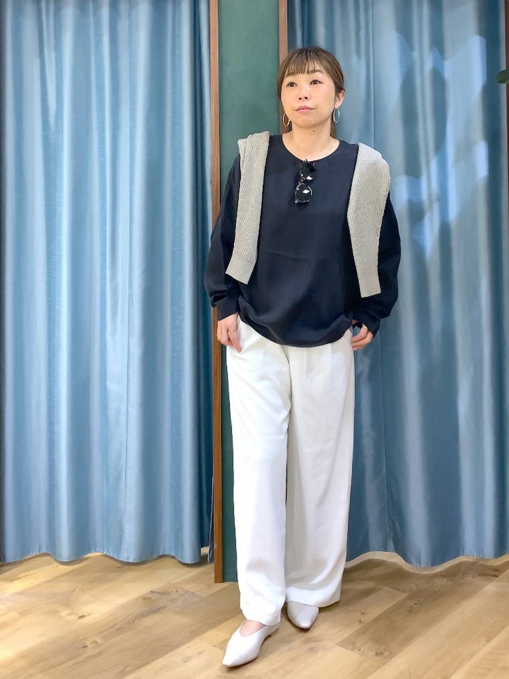 ホワイト系のスラックス、ベージュ系のカーディガン/ボレロ、ホワイト系のパンプスを着用したレディースの冬コーディネートの3枚目の写真