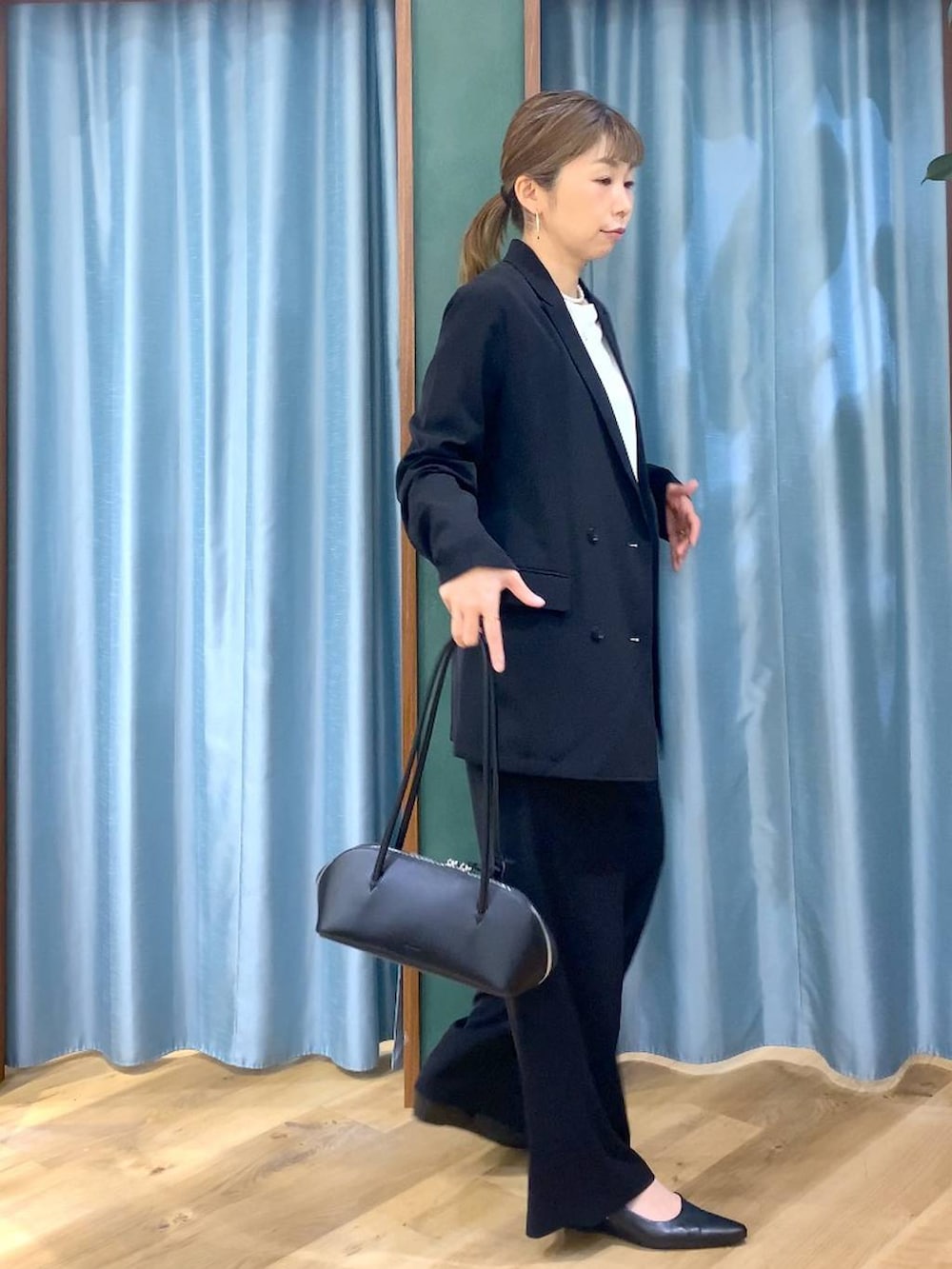 ブラック系のスラックス、ホワイト系のTシャツ/カットソー、ブラック系のテーラードジャケットを着用したレディースの冬コーディネートの6枚目の写真