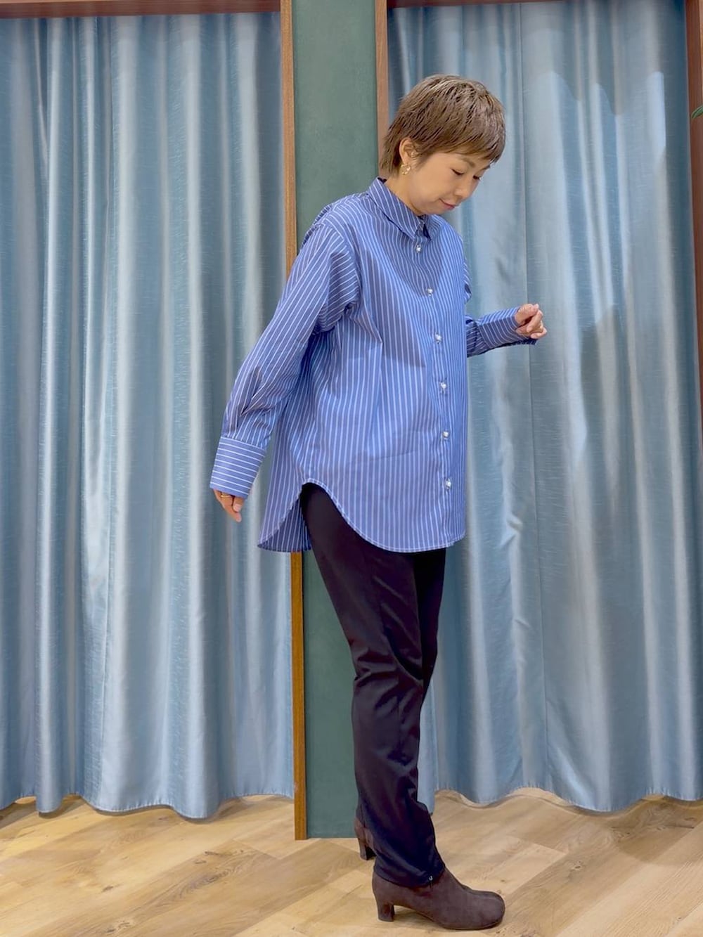ブラック系のその他パンツ、ブラウン系のブーツ、ブルー系のシャツ/ブラウスを着用したレディースの秋コーディネートの6枚目の写真
