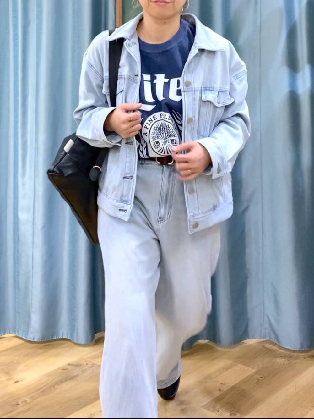 ブラック系のブーツ、ブラック系のバックパック/リュック、ブルー系のデニムパンツを着用したレディースの冬コーディネートの6枚目の写真