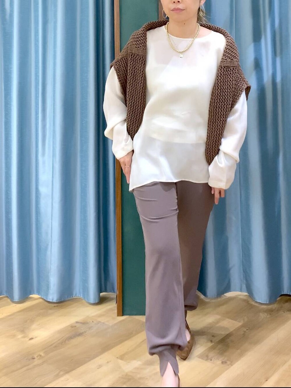 ブラウン系のニット/セーター、グリーン系のその他パンツ、ホワイト系のシャツ/ブラウスを着用したレディースの冬コーディネートの8枚目の写真