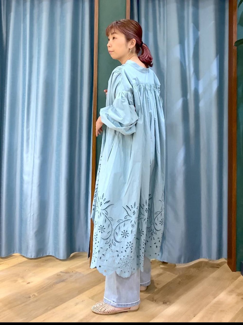 ブルー系のデニムパンツ、ベージュ系のスリッポン、グリーン系のワンピースを着用したレディースの春コーディネートの5枚目の写真