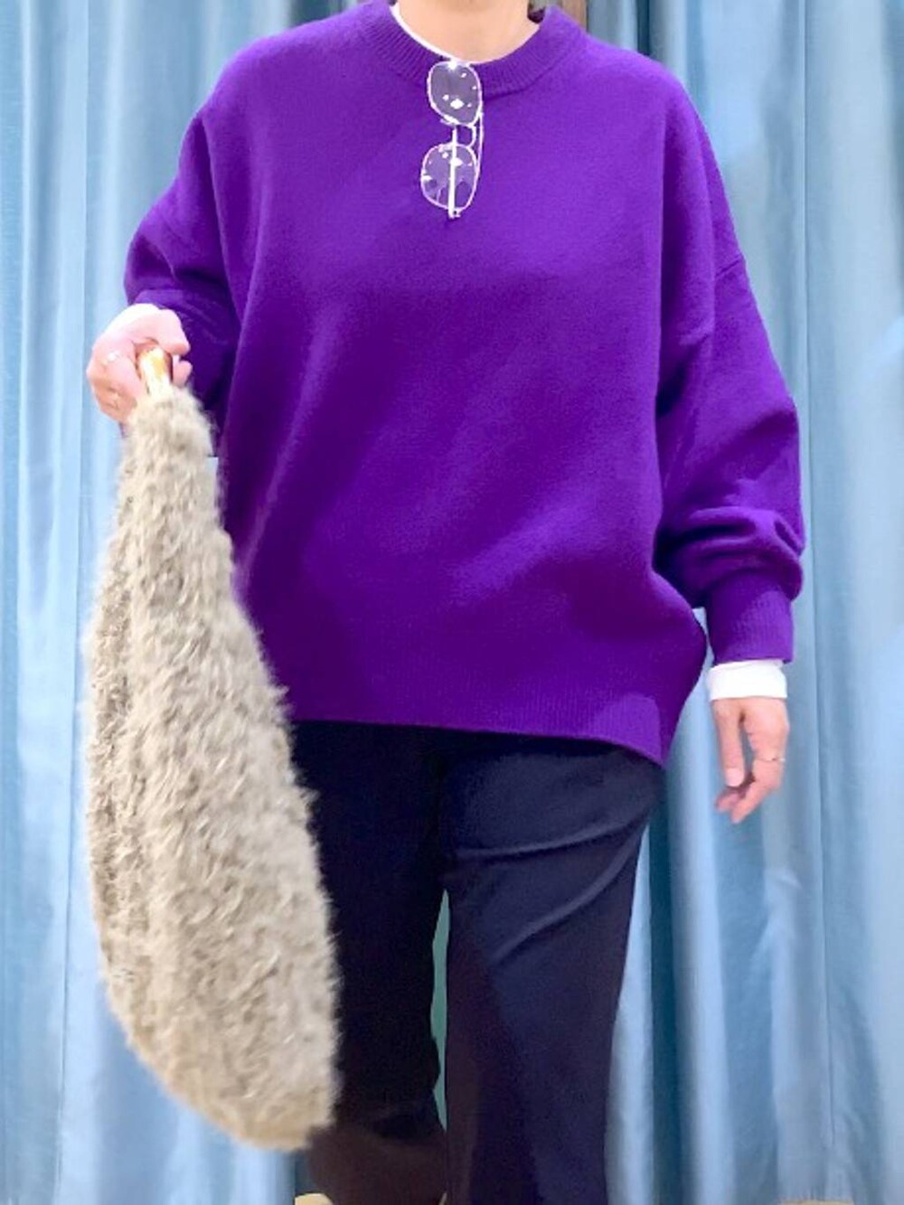 パープル系のニット/セーター、ベージュ系のハンドバッグ、ブルー系のその他パンツを着用したレディースの秋コーディネートの6枚目の写真